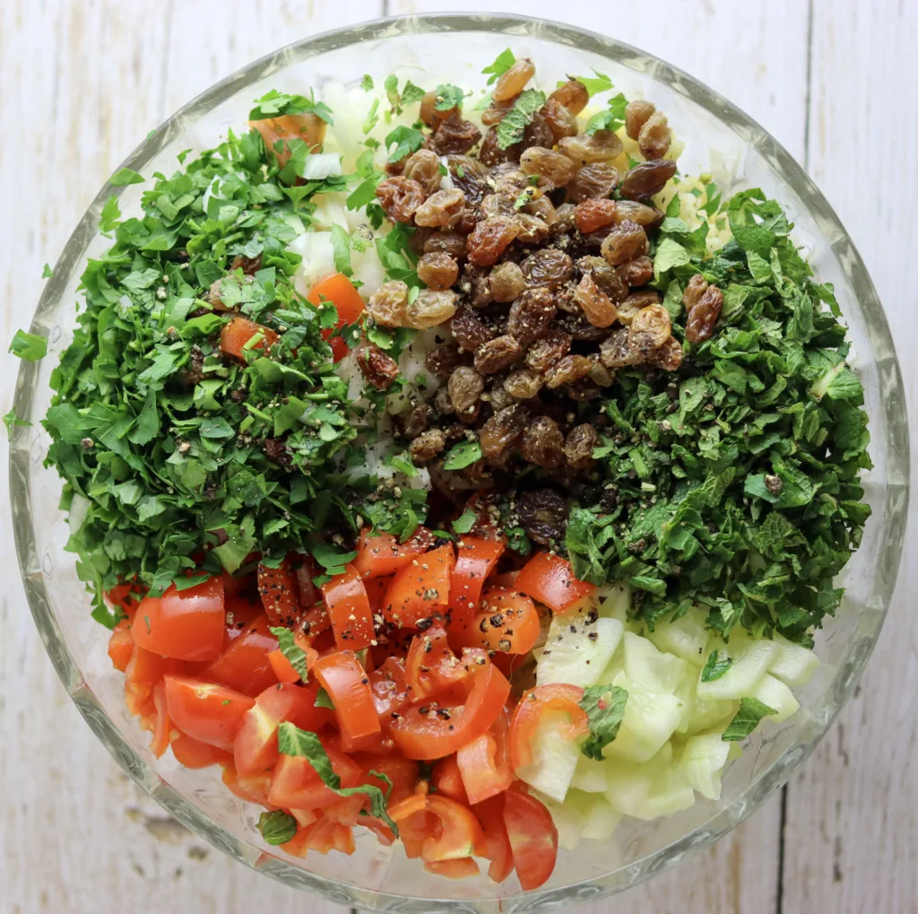 mixing the vegetables, bulgur, spices with mint leaves and parsley leaves