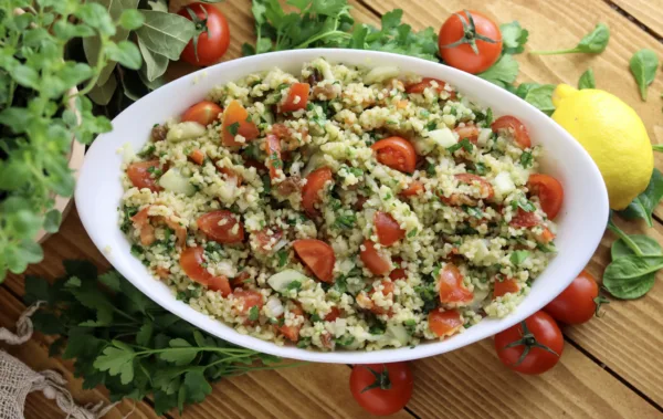 taboule oriental on the table with fresh spices, lemon and tomatoes
