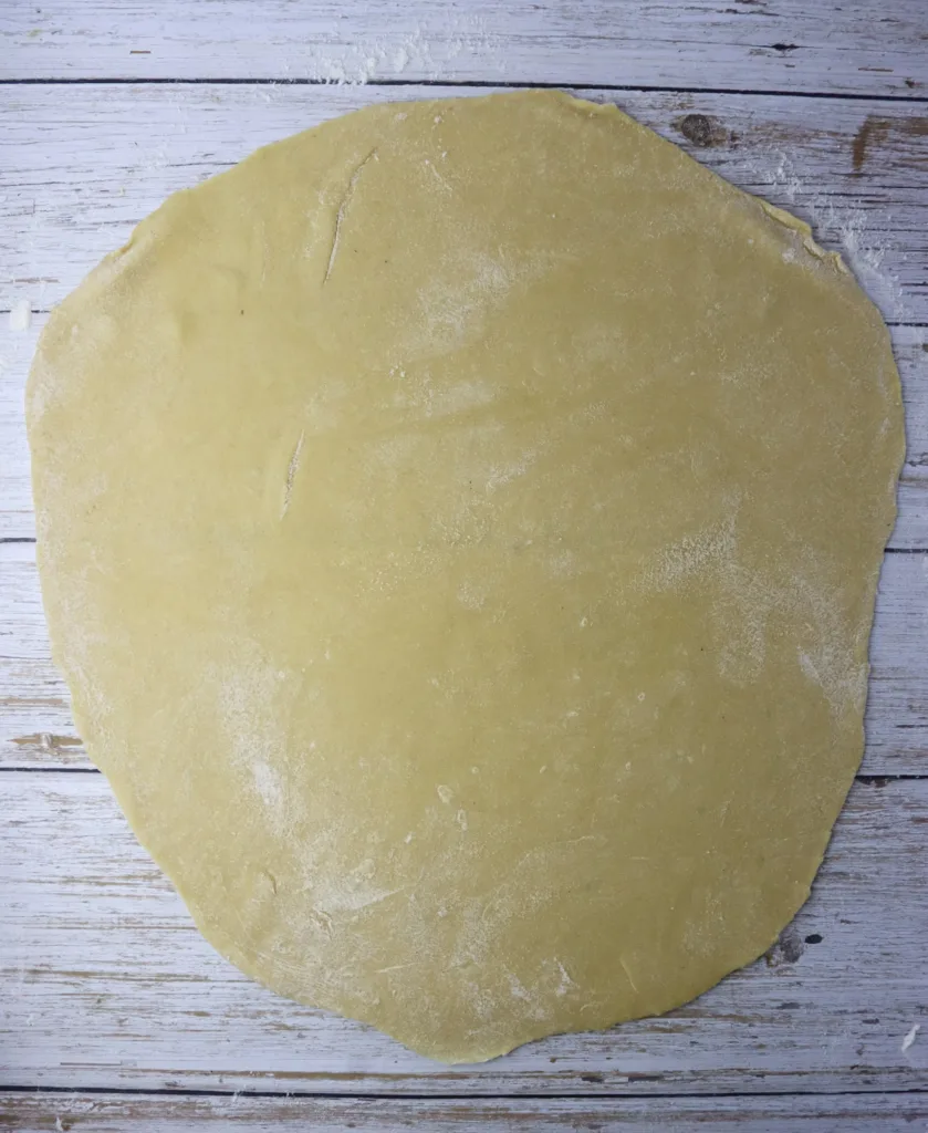 step - image showing how to roll out the dough before cutting empanada discs