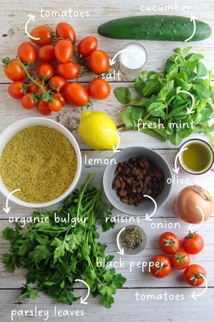gathering ingredients for taboule oriental: organic bulgur, parsley leaves, mint, tomatoes, cucumber, an onion, lemon, raisins, salt and black pepper
