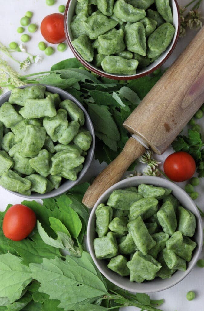 image of green gnocchi with wild spinach, other greens and cherry tomatoes