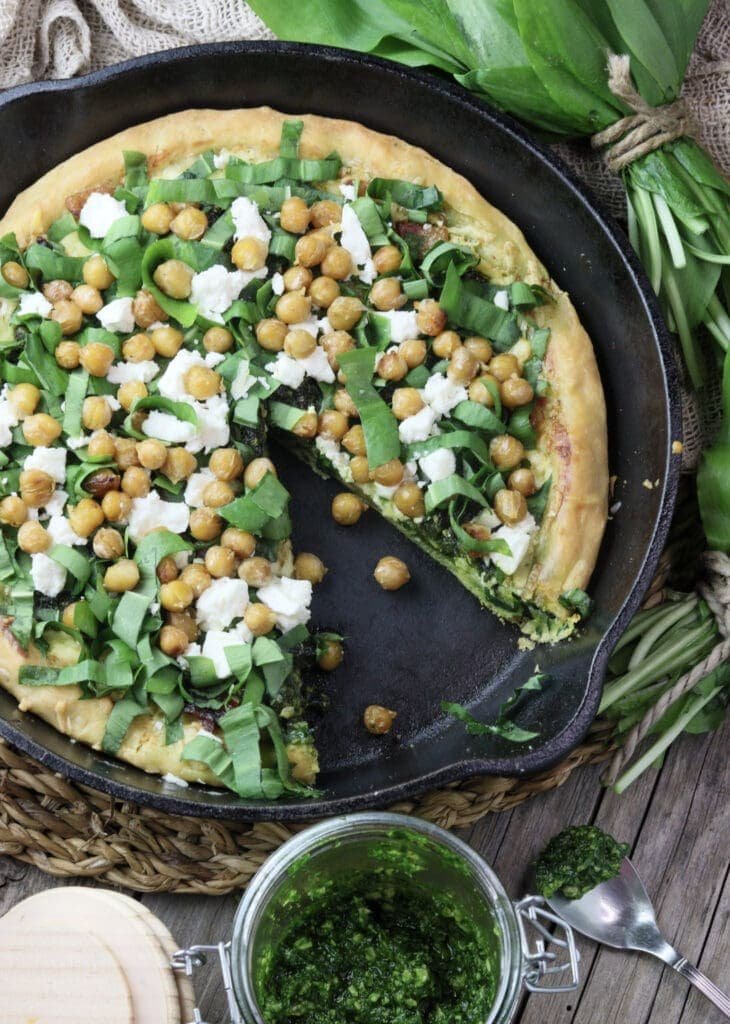 image of wild garlic pizza with roasted chickpeas and feta cheese in a cast iron skillet