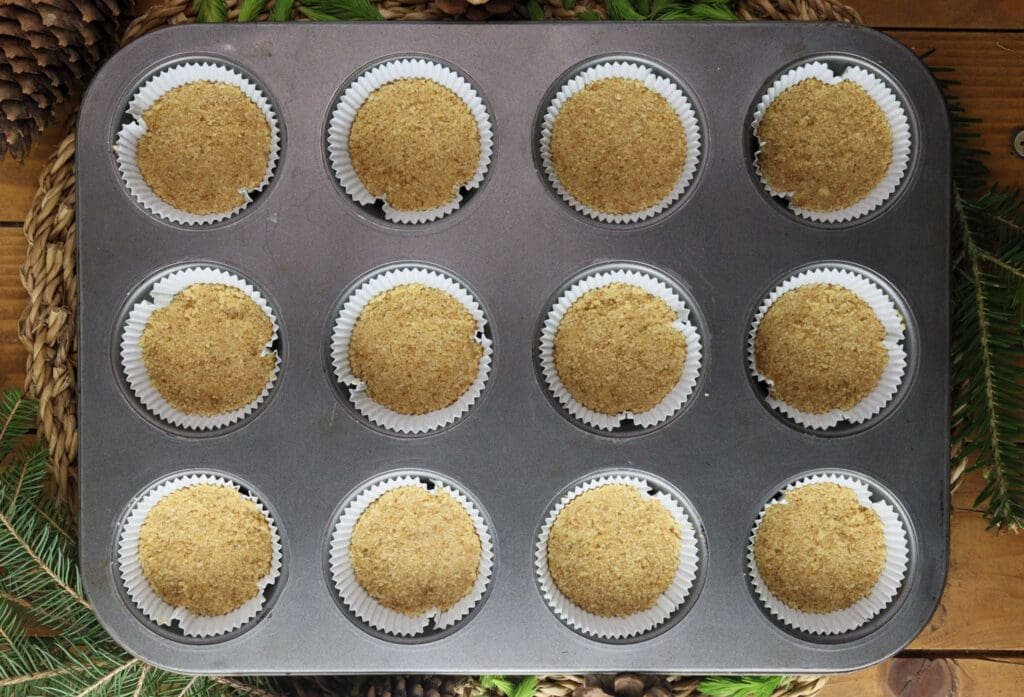 Filling the muffin paper liners with the cookie mixture for a delightful, crunchy cake base. 