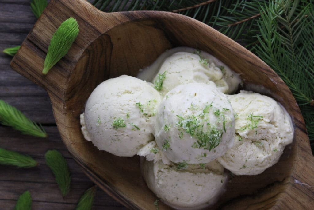image of scoops of no churn spruce tip ice cream sprinkled with spruce tip sugar