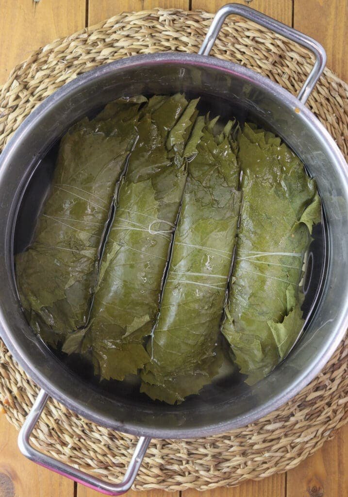 Blanching grape vine rolls for japrak in the winter.