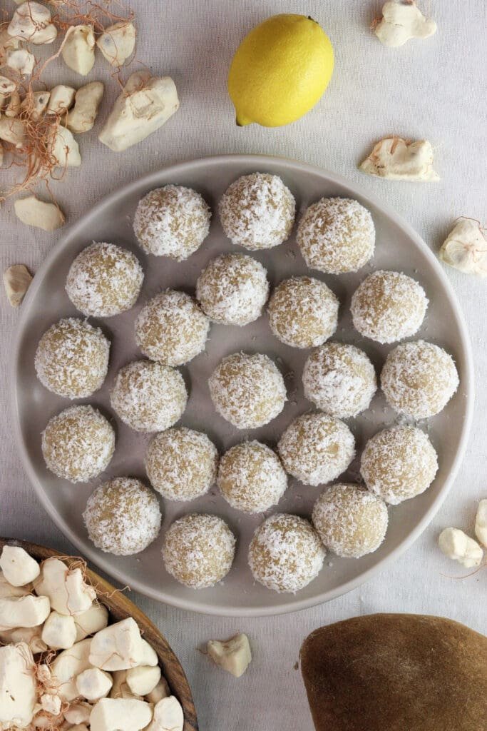 coconut baobab balls-bites on a plate with a lemon in the background