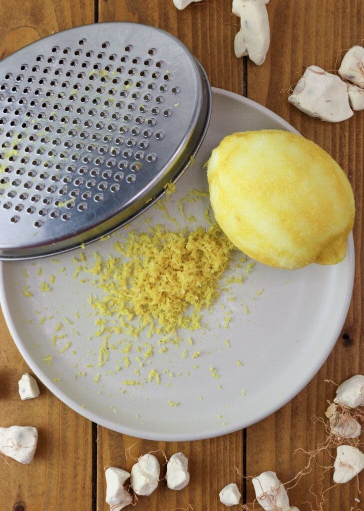 Grating a lemon for two tsp of fresh lemon zest 