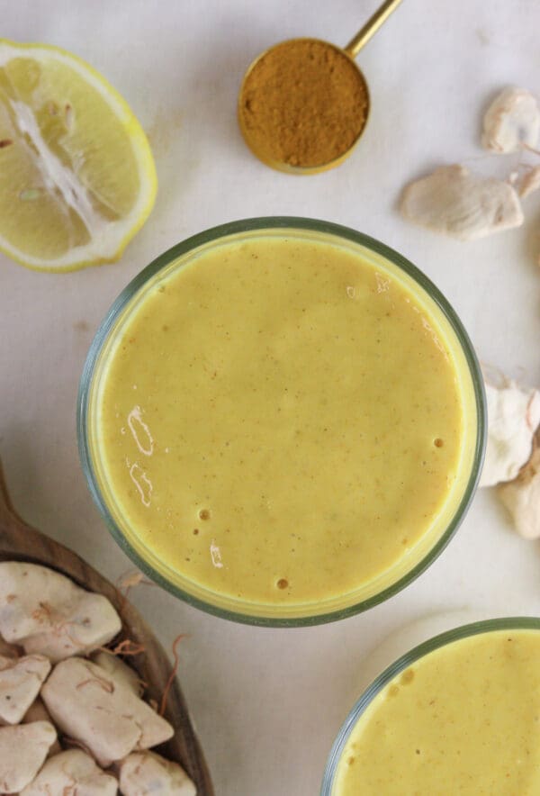 Image of a glass of baobaob smoothie with giinger and baobab fruit pulp in the background