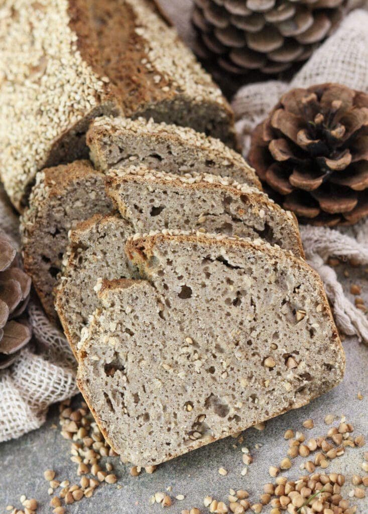 A loaf of gluten-free buckwheat soda bread cut into three thick rustic slices.