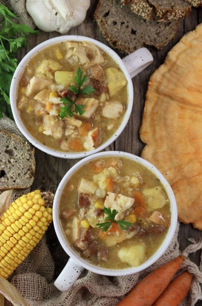 Minestra soup with chicken of the woods mushrooms served in bowls and bread in the background. 