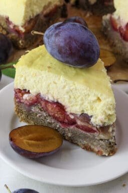 A slice of plum cheesecake with a plum