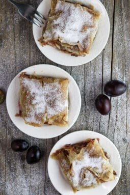 Three plates of delicious plum strudel with cinnamon.