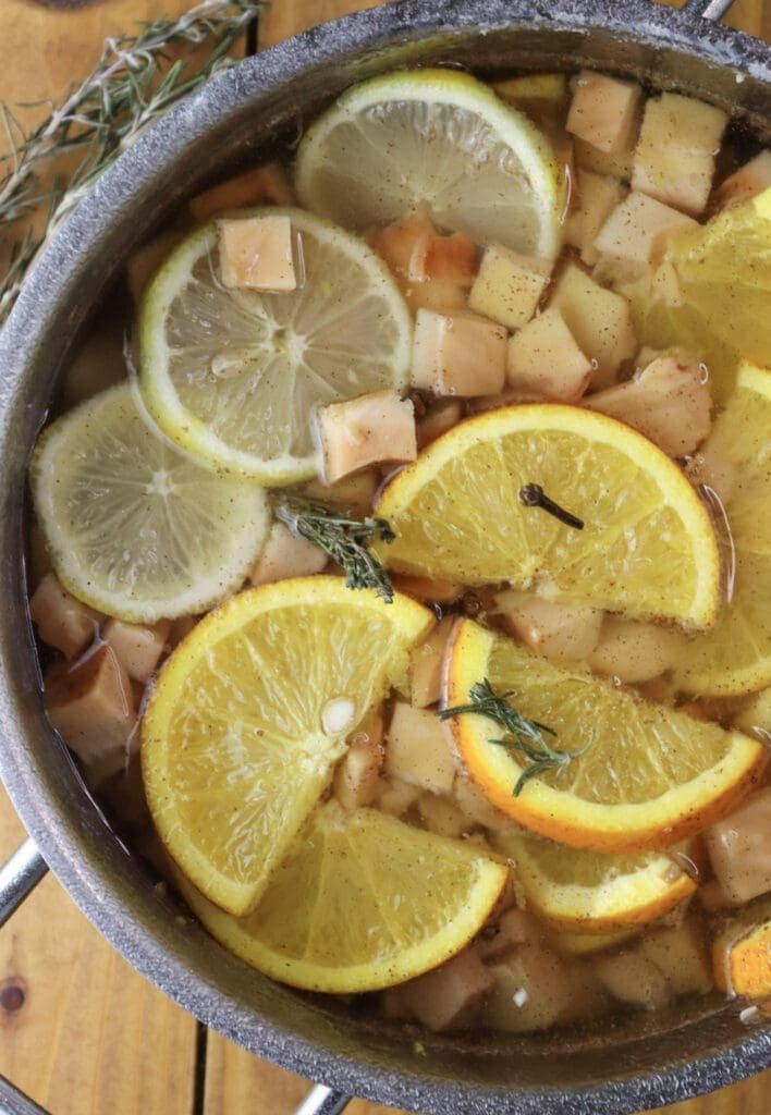 Image of chicken of the woods cooking together with orange, lemon, rosemary and cloves in sweet sugar syrup