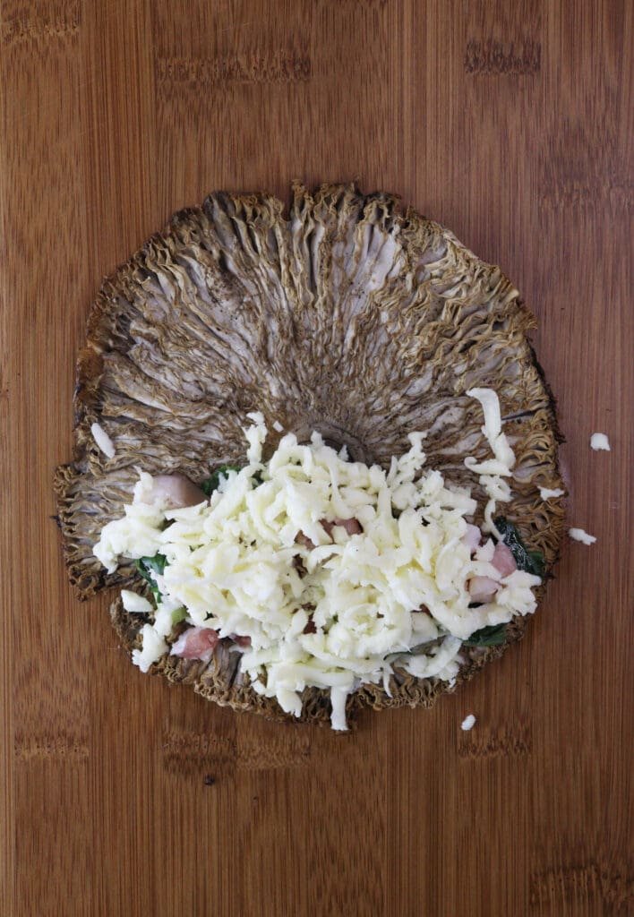 The mushroom topped with mozzarella cheese, young onion and smoked baking before rolling