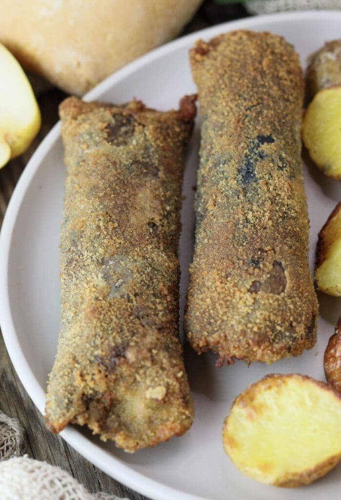 close-up of crispy fried parasol mushroom rolls with melted mozzarella cheese and potatoes