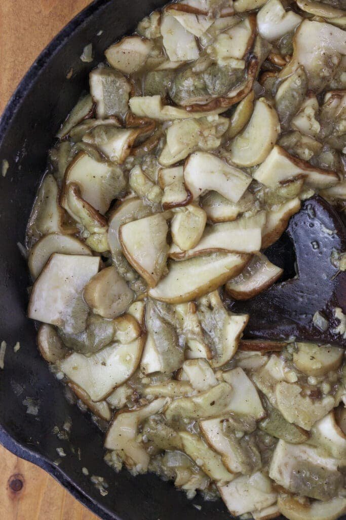 Image of porcini mushrooms sauteeing in a pan with white wine for porcini sauce