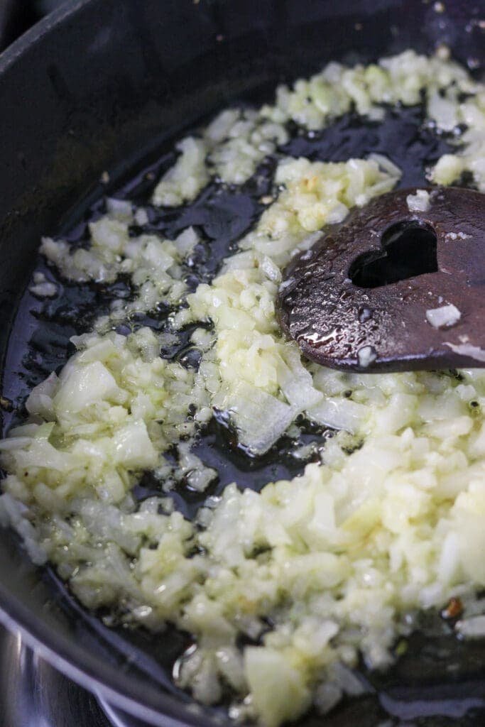 Image showing how to stir fry the onion and garlic while stiring constantly until golden and translucent