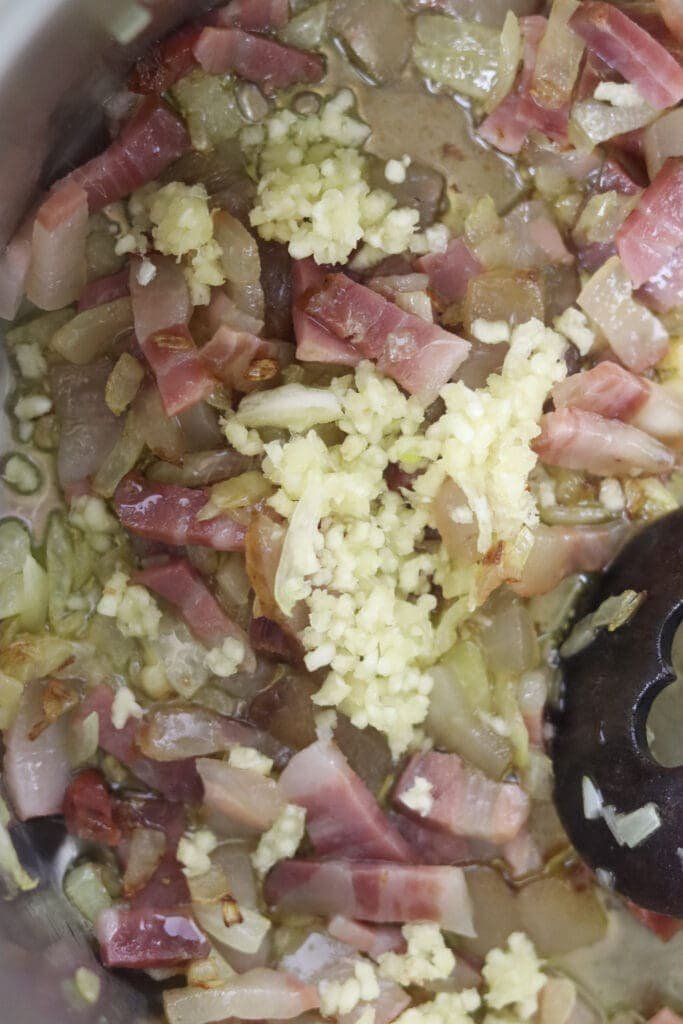 How to add crushed garlic to smoked bacon and onions right before adding potatoes, sauerkraut, beans and sausages