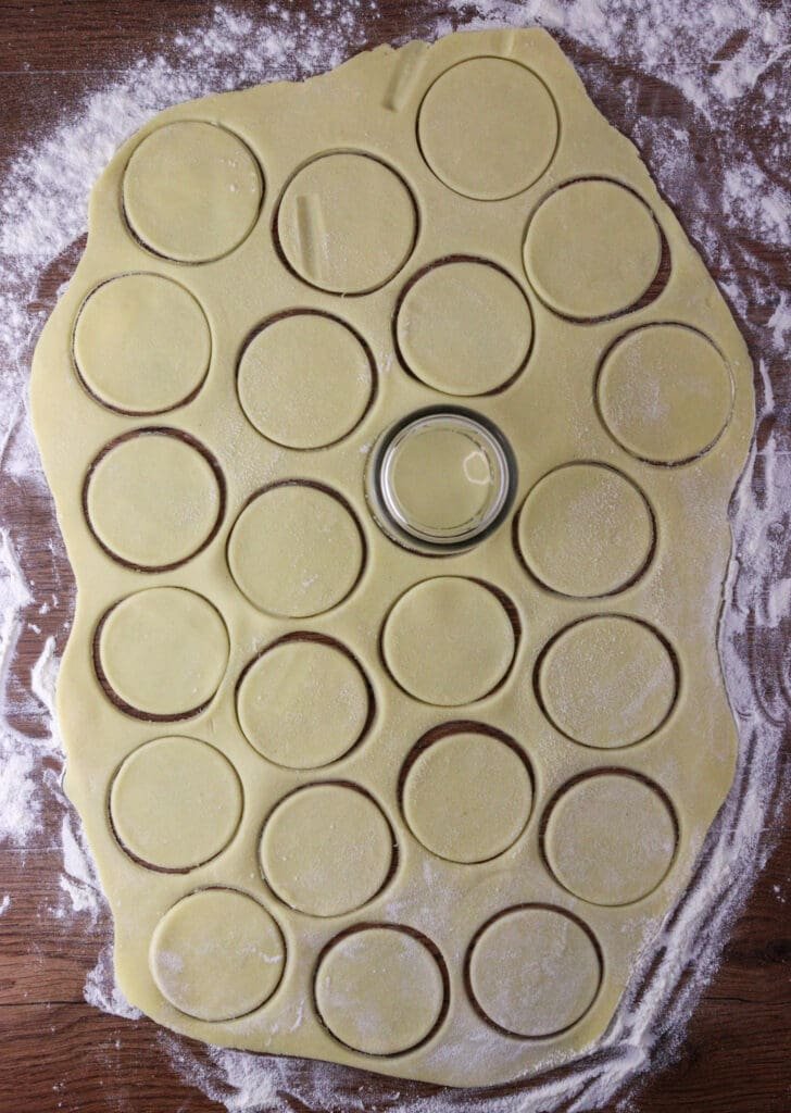 How to cut the dough into empanada discs using an empty glass or a cookie cutter