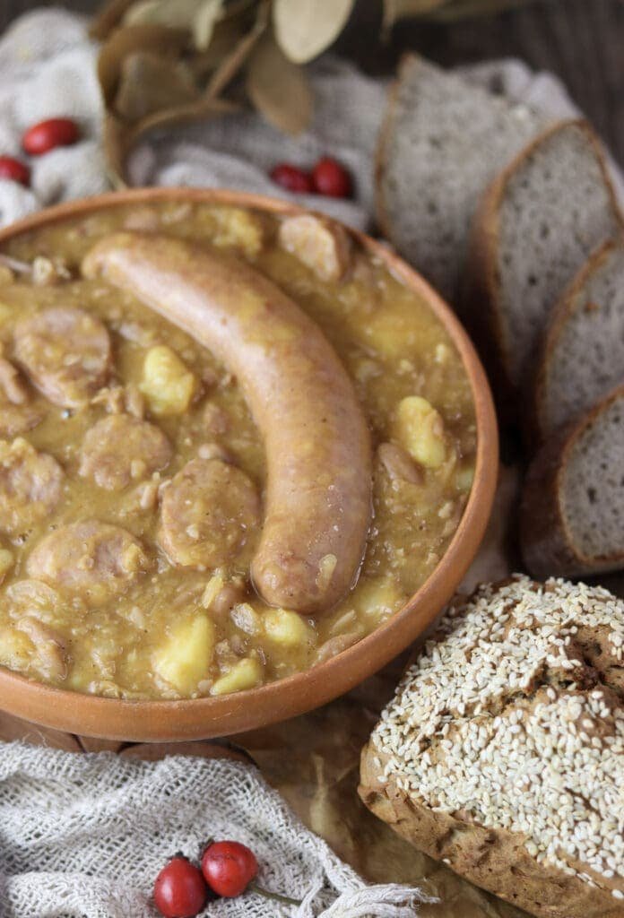 Slovenian jota soup made by a traditional recipe, served on a table with fresh homemade bread