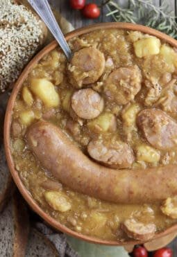 Freshly cooked jota soup with homemade bread in the background.
