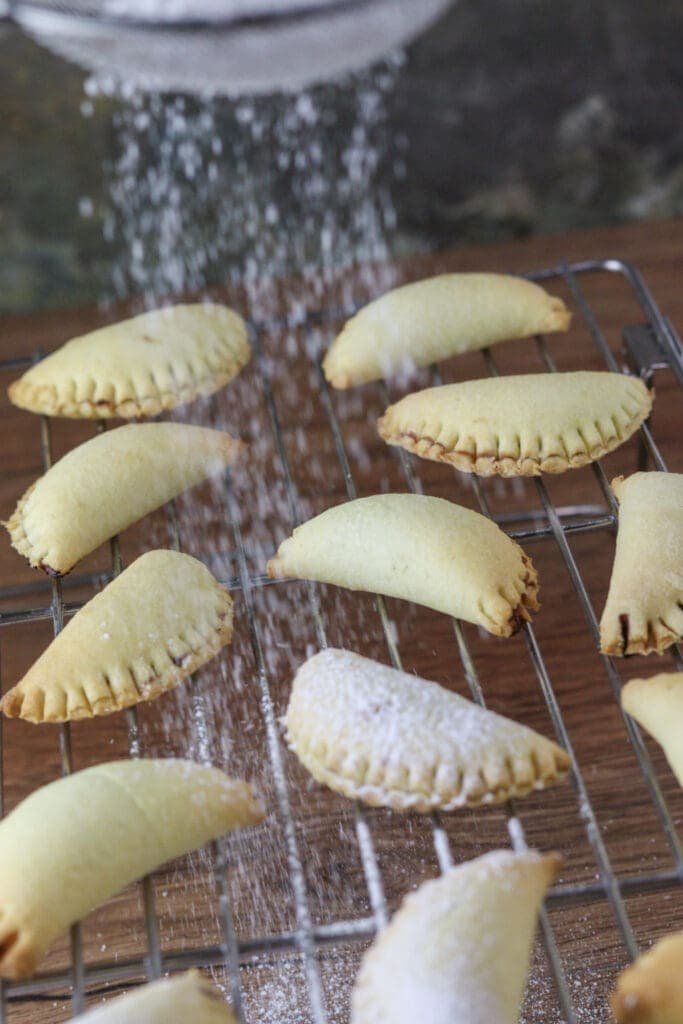 Dusting the cookies with powdered sugar placed in a small strain