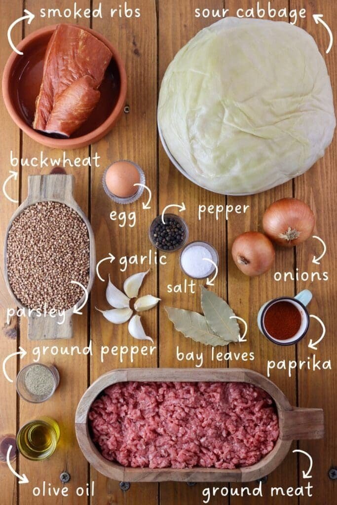 Ingreedients mis en place for cabbage rolls with buckwheat; Buckwheat grains, sour cabbage leaves, smoked bacon, an egg, whole black pepper, ground black pepper, paprika powder, salt, olive oil, two onions, ground meat, garlic and bay leaves.