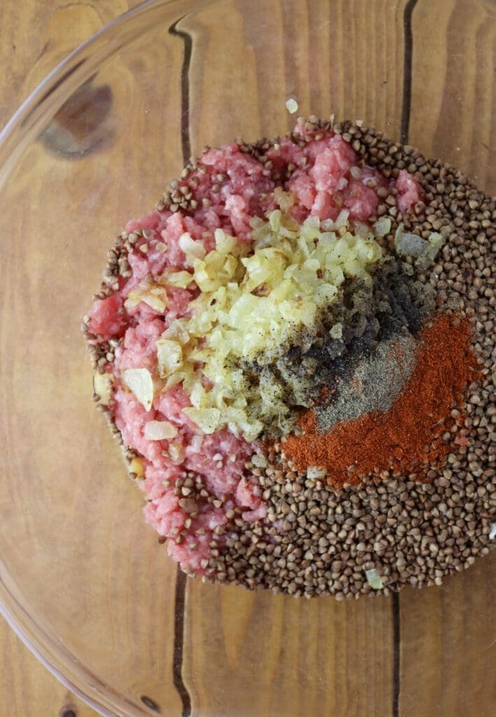 Stuffing for cabbage rolls ingredients mixed in a bowl; buckwheat groats, fried onions, ground meat, black pepper, salt, paprika and one egg.