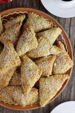Crispy golden brown cracling cookies with sesame ona an old clay plate.