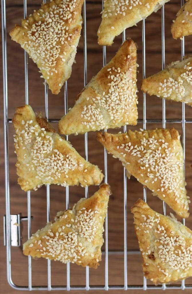 Cracling cookies with sesame seeds on a cooling rack, waiting to chill to room temperature.
