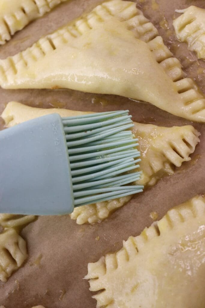 Covering the cookies with an egg wash before sprinkling them with sesame seeds.