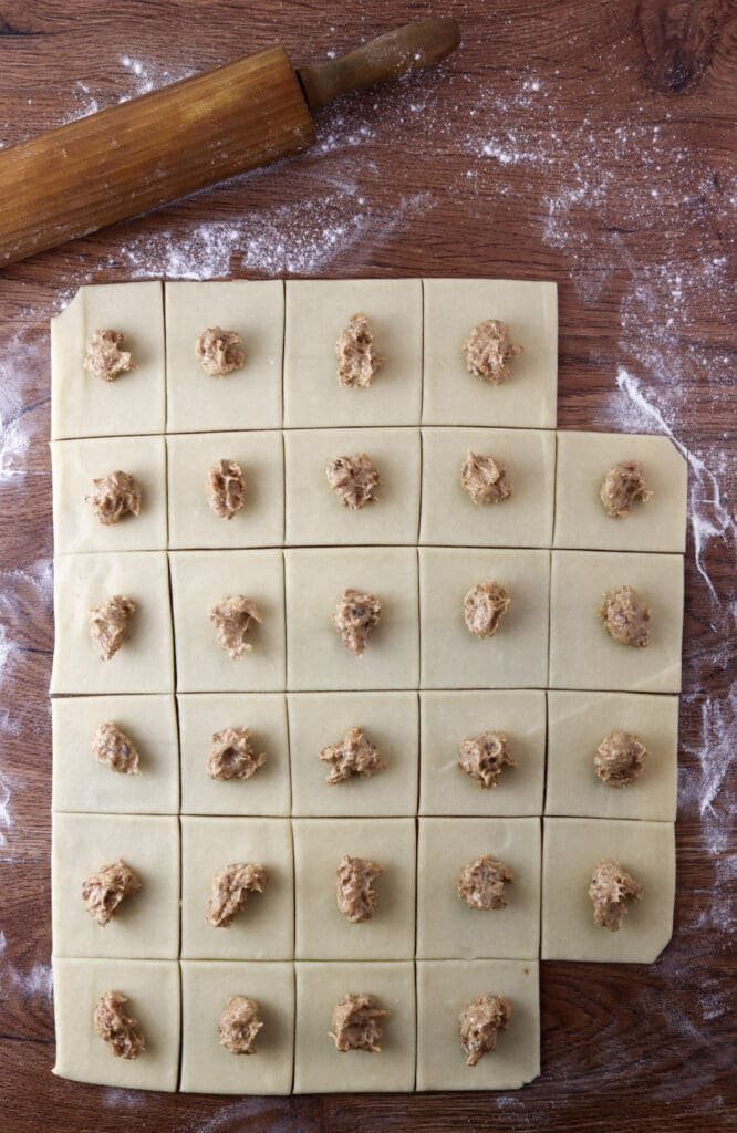 Filling the dough squares with cracling and lard filling.