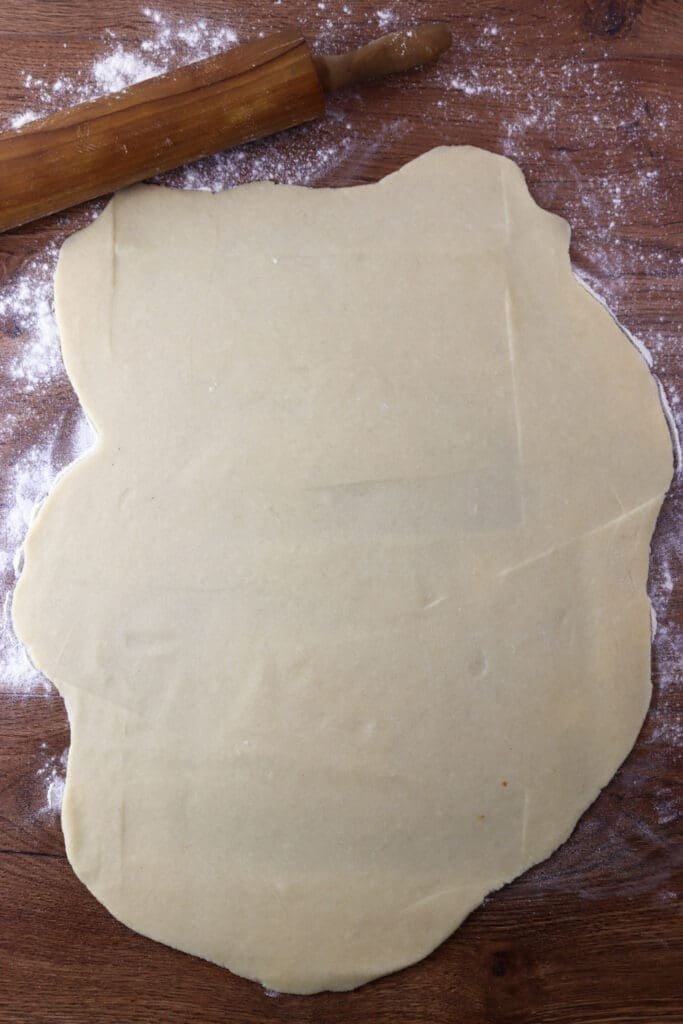 Rolling the cookie dough before cutting it into smaller sizes.
