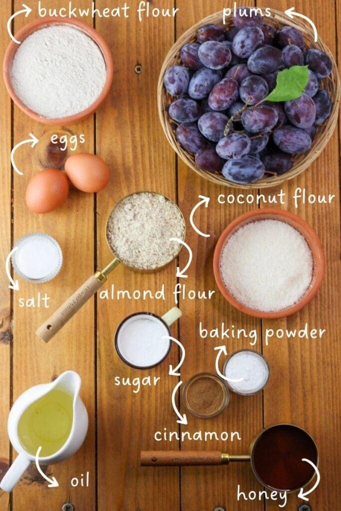 Ingredients mis en place for buckwheat upside down plum cake: buckwheat flour, fresh plums, coconut flour, almond flour, eggs, salt, baking powder, sugar, cinnamon, oil and honey.