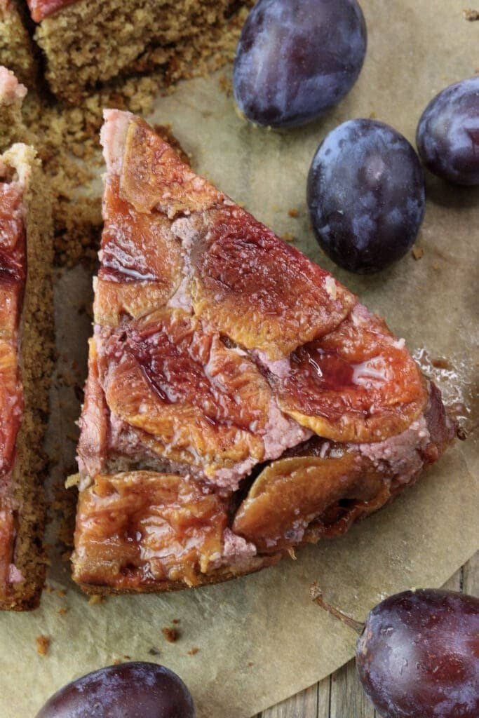 A juicy slice of upside down buckwheat plum cake with fresh plums.