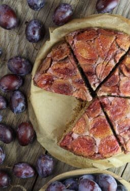 Slices of delicious upside down plum buckwheat cake served on the table.