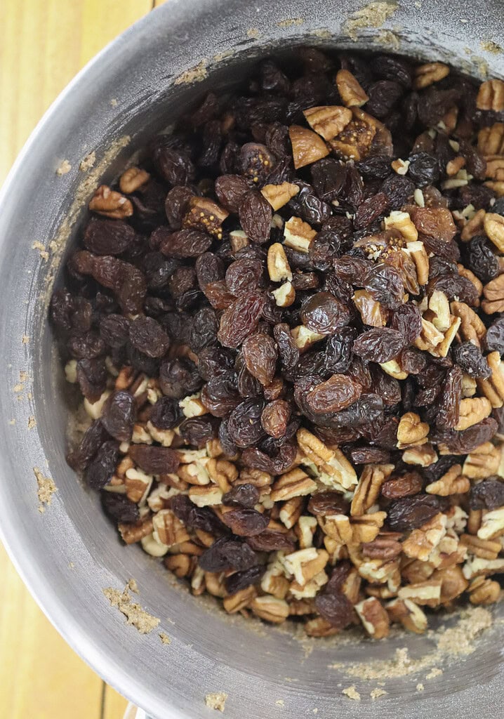 Adding chopped fruits and nuts to the cookie batter.