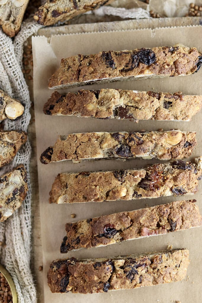 Sliced buckwheat biscotti on a wooden board, showing the inside texture.