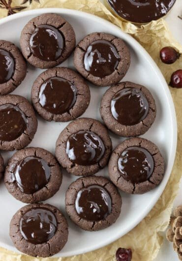 A full plate of buckwheat thumbprint cookies with chocolate filling with added orange zest.