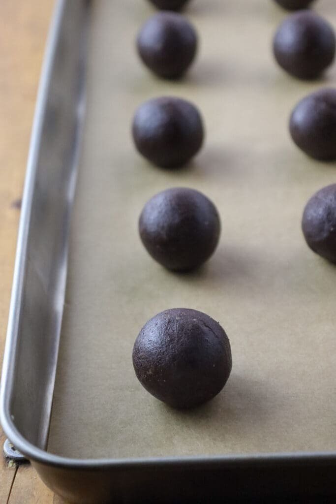 How to create small balls of dough and place them on a baking tray before creating an indentation.