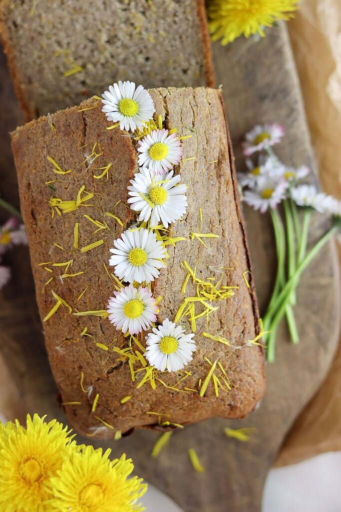Freshly baked gluten free dandelion bread with honey, decorated with flowers.