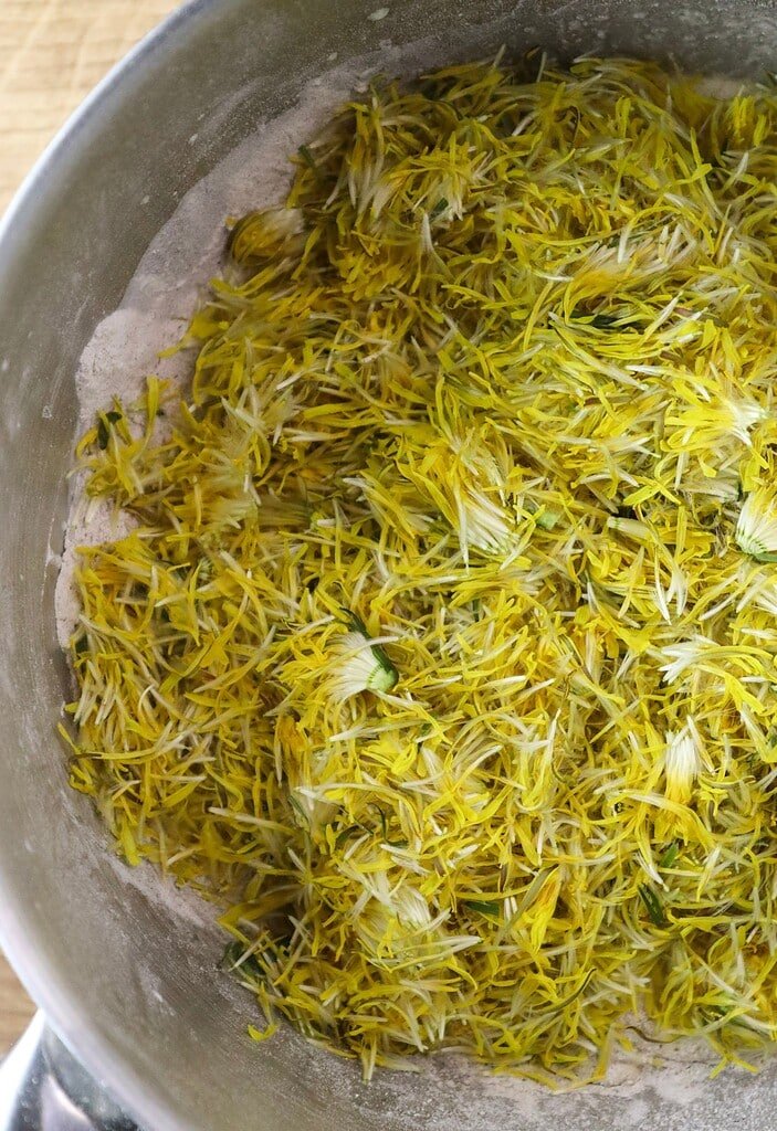Adding dandelion flower petals to the batter.