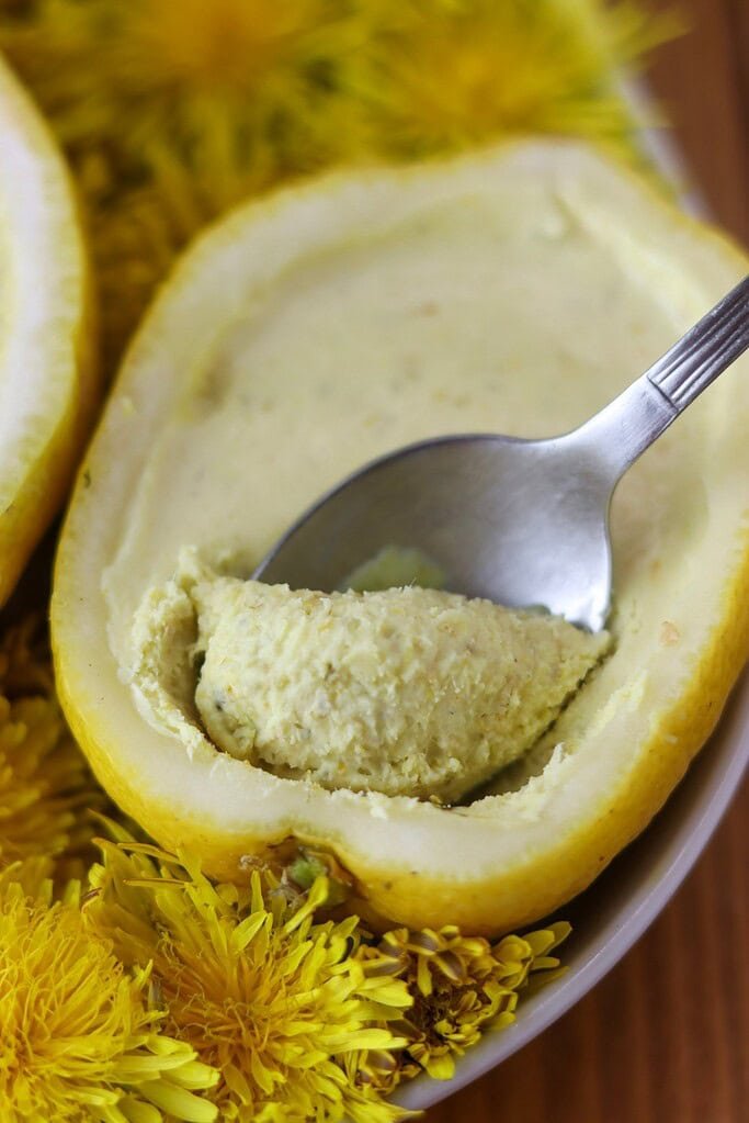 A spoonful of dandelion lemon dessert with visible dandelion petals in the filling.